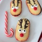 Milano reindeer cookies on a plate with a candy cane
