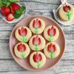 strawberry tulip cookies - seven cookies adorned with strawberry tulips on a plate
